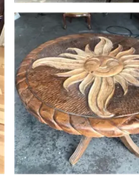 Carved wooden accent table with a sun face carving